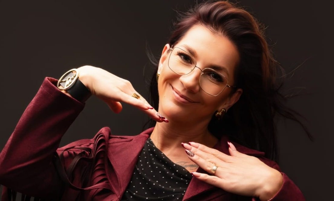 Gosia, kapper en eigenaar van Gosia Fryzjer, in een wijnrood jasje