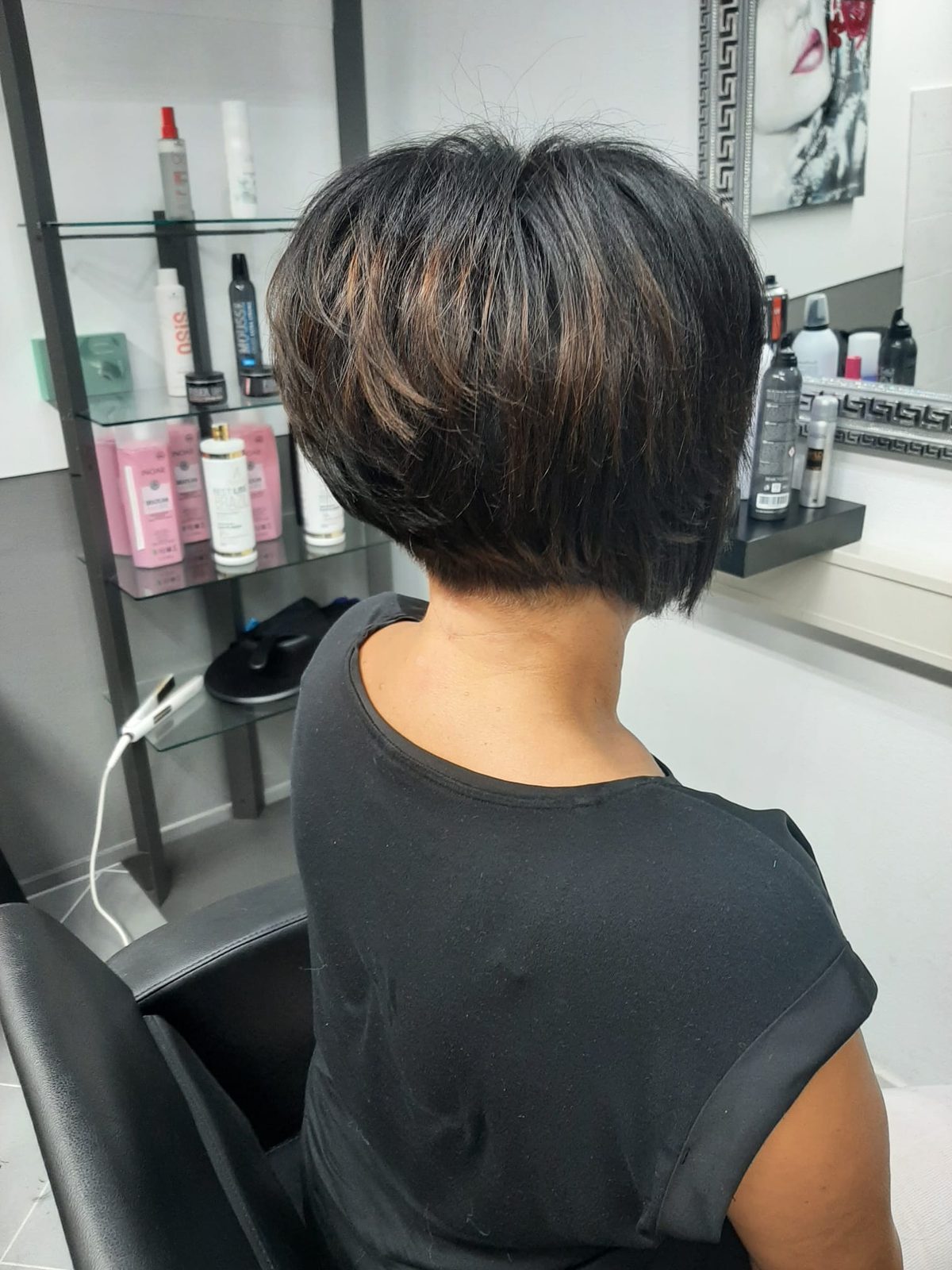 Een korte, opgeknipte bob met warme highlights, van achteren gezien in de salon